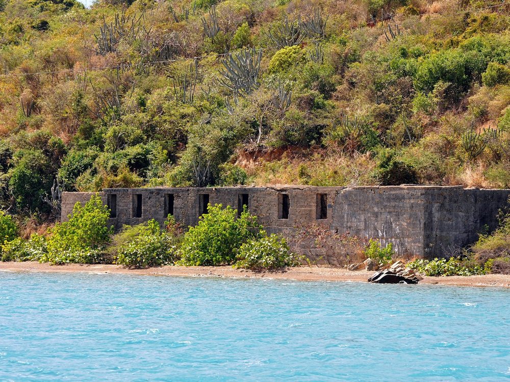 Old stone ruins above turquoise water on the St. Thomas coast